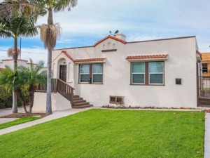 Small southwestern style stucco home with red terra cotta roof