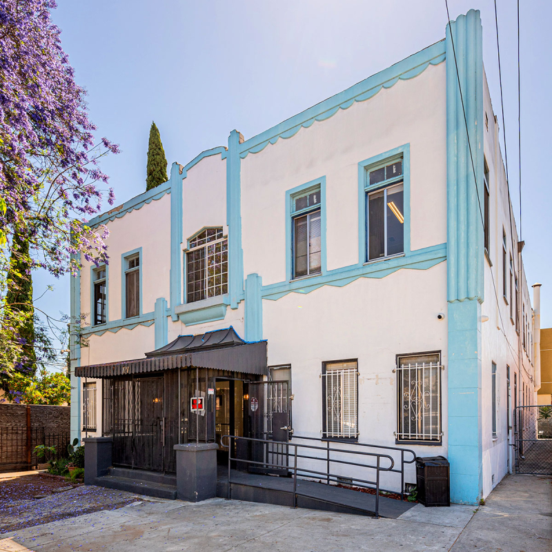 Front corner view of white Art Deco building with light blue trim